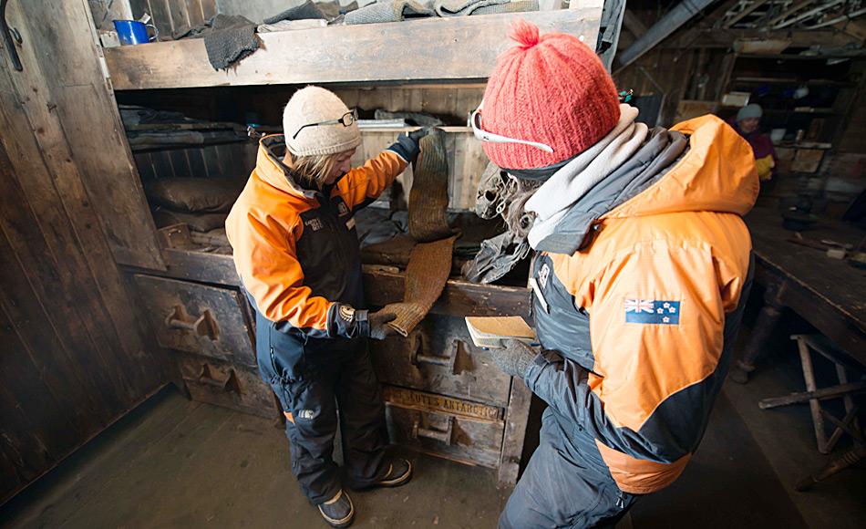 Restauratorin Nicola Dunn und Projekt Manager Lizzie Meek notieren die Position von Objekten, in diesem Fall ein Paar Stulpen, in Scott, Hütte bei Cape Evans. Foto: Alasdair Turner