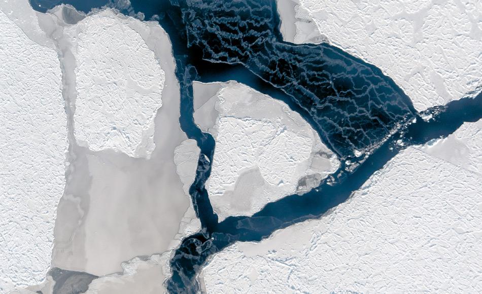 Der Wind hat ein Eisfeld auseinander getrieben und eine Fläche offenen Wassers geschaffen. Dessen Oberfläche gefriert sofort wieder, wie die weißen Schlieren verraten. Sie entstehen, wenn der Wind lose Eiskristalle verweht. Foto: IceCam/Stefan Hendricks